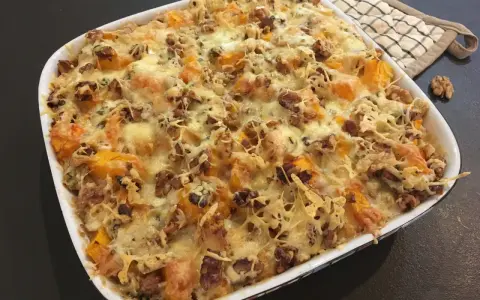 Gratin de courge butternut et noix, gratiné au fromage, avec des touches de Fourme d'Ambert pour une saveur unique.