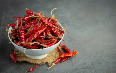 Miseczka pełna suszonych papryczek chili, których ostrość pochodzi od kapsaicyny. Co to jest kapsaicyna? To związek chemiczny odpowiedzialny za pieczenie.