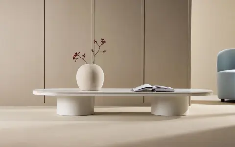 Ett minimalistiskt, coolt soffbord i vitt med en rund vas med torkade blommor och en öppen bok.