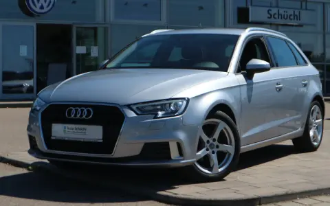 Silberner Audi A3 Avant steht vor einem Autohaus.