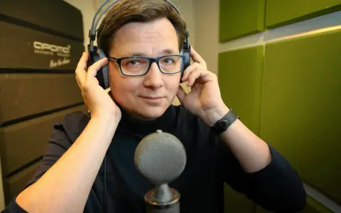 Mężczyzna w słuchawkach i okularach, gotowy do nagrania. Może to lektor porno, a może czyta bajki.