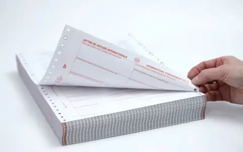 Stos papierów z nadrukiem "CMR" i "INTERNATIONAL CONSIGNMENT NOTE". Dokumenty te służą do międzynarodowego przewozu towarów.