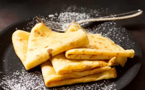 Délicieuses crêpes dorées, saupoudrées de sucre glace, prêtes à être dégustées. La pâte à crêpe Thermomix, un jeu d'enfant !
