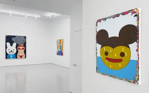 A gallery showcases vibrant paintings by Eli Klein. One features a cartoon rabbit and bikini-clad torso with smoke, another a colorful abstract, and a large piece with a yellow, Mickey Mouse-like face.