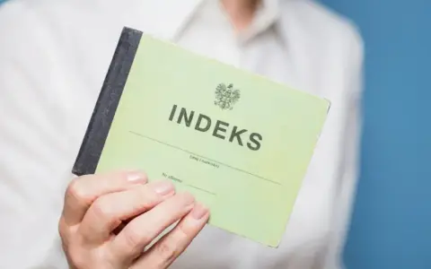 Zielony indeks, symbol studiów magisterskich w Łodzi, w dłoni studenta.