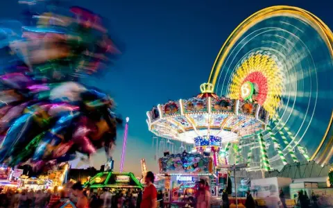 Buntes Treiben am Familientag Kirmes mit Karussells, Riesenrad und Lichtern.