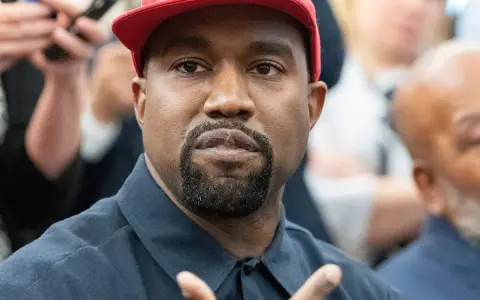 Kanye West w czerwonej czapce i granatowej koszuli, podczas wywiadu.