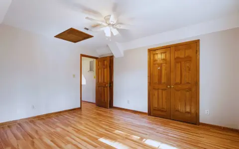Habitación con suelo de madera clara y puertas de madera oscura, creando un contraste cálido.