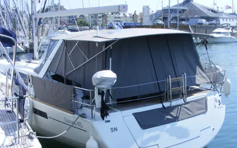 Bateau avec taud de soleil intégral, offrant une protection complète. La différence entre bimini et taud de soleil est claire : le taud couvre plus.