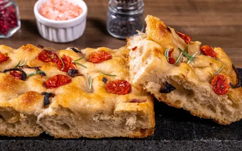 Pyszna, oryginalna włoska focaccia z pomidorkami i rozmarynem. Idealna na przekąskę lub dodatek do dania.
