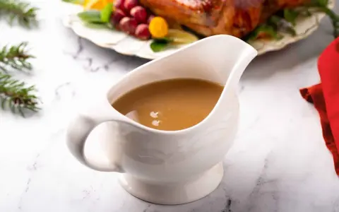 Saucière en porcelaine remplie d'une sauce pour dinde succulente, prête à accompagner le festin de Noël.
