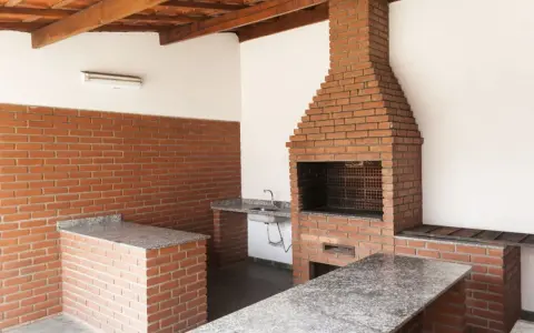Solidny grill murowany z cegły, projekt z blatem i zlewem. Idealny na rodzinne spotkania.