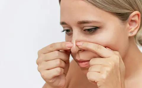 Kvinna undersöker sin näsa, kanske för pormask behandling.