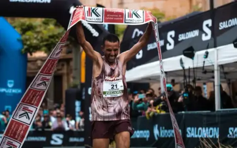 Corredor celebra su victoria en la **Zegama-Aizkorri** rompiendo una cinta.