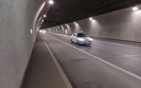 Biały samochód mknie przez oświetlony tunel w Zakopanem.