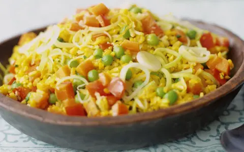 Bunter Reis mit Erbsen, Karotten und Lauchringen, inspiriert von Safran-Rezepten.