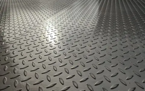 Metalowa podłoga z wytłoczonym wzorem, w odcieniu szarości, który można określić jako ral 9007 jaki to kolor.