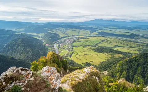 Widok z góry na dolinę z rzeką i miasteczkiem, w oddali majaczą góry, przypominające trzy korony.