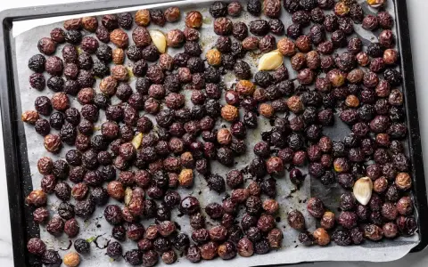 Olive nere al forno alla pugliese, dorate e profumate con aglio, pronte per essere gustate.
