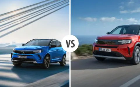 Niebieski i czerwony Opel SUV jadące po drogach, z mostem w tle.