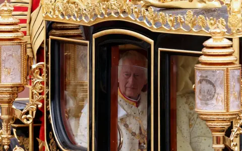 Król Karol III w złotej karocy, symbolizujący jego panowanie. Król karo znaczenie jest widoczne w jego dostojnym wyglądzie.