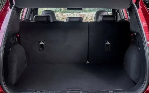 Maletero del Ford Kuga con asientos abatidos, listo para cargar equipaje o compras. Se aprecian los anclajes ISOFIX.