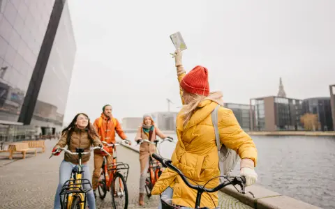 Amici esplorano Copenaghen in bicicletta, godendosi la libertà di muoversi con le biciclette gratis.