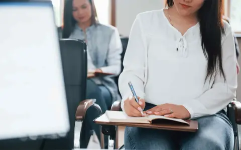 Estudiantes toman notas en clase. Se registran los gastos de formación en la cuenta contable.
