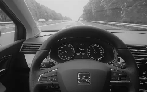Blick auf das Armaturenbrett eines Autos mit aktiviertem Tempomat. Der Tacho zeigt 100 km/h.