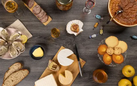 Un festin normand : huîtres, fromages, charcuterie, pommes et douceurs, accompagnés de verres de Calvados, pour savourer les spécialités locales.