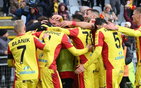 Piłkarze Korony Kielce świętują zwycięstwo nad Górnikiem Zabrze. Radość i okrzyki na boisku, kibice na trybunach.