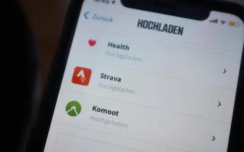 Na ekranie telefonu widać aplikację Strava po polsku, obok Health i Komoot.