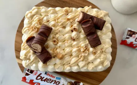 Un délicieux tiramisu Kinder Bueno, garni de morceaux de chocolat et de noisettes concassées. Un vrai régal pour les gourmands !