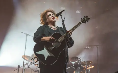 Robert Smith von The Cure spielt auf einer Gitarre mit weißem Stern.