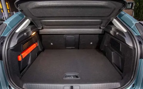 Maletero Citroën C4 vacío, con el triángulo de emergencia naranja visible a la izquierda. Espacio de carga listo para tus aventuras.