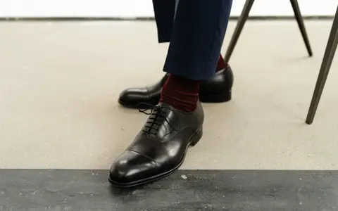 Eleganckie, czarne oksfordy to klasyczne rodzaje męskich butów. Wygodne, z bordowymi skarpetkami, idealne na formalne okazje.
