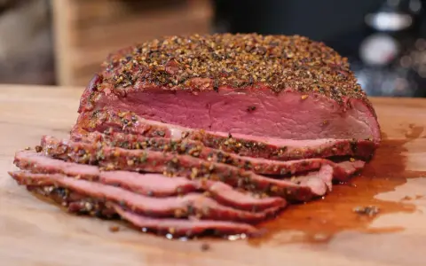 Perfekt gegrilltes Roastbeef mit kräftiger Gewürzkruste, saftig rosa geschnitten auf einem Holzbrett. Ein Genuss für jeden Grillmeister!