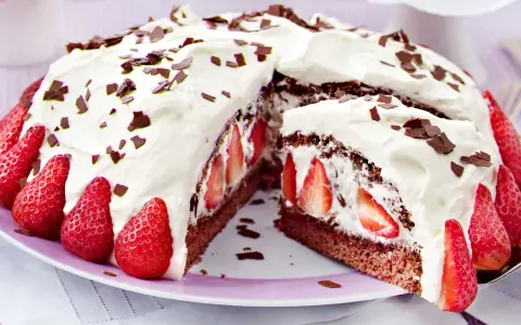 Saftige Stracciatella Torte mit frischen Erdbeeren und Schokostückchen, üppig mit Sahne verziert.