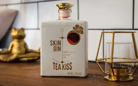 Flasche "Skin Gin Tea Kiss" neben einem goldenen Frosch und Kerzenhalter. Die Frage, wie viele Gin-Sorten es gibt, bleibt offen.
