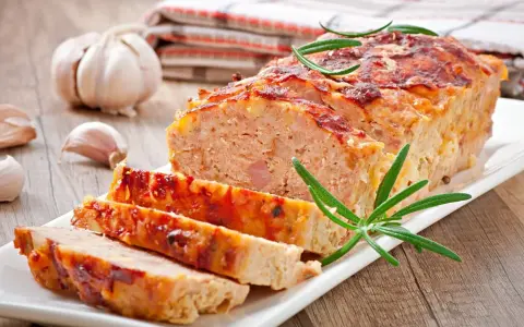 Tradycyjny klops, pokrojony na plastry, z czosnkiem i rozmarynem. Idealny przepis na obiad.