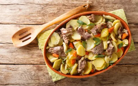 Un plat de pommes de terre et de viande mijotée, garni d'herbes fraîches, une spécialité alsace réconfortante.