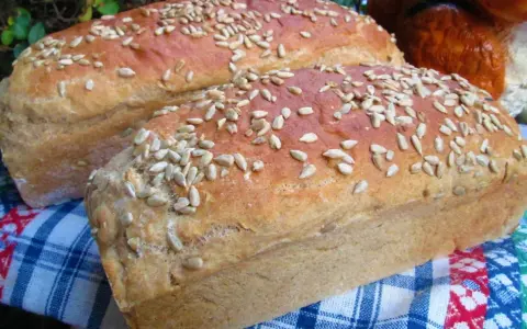 Dwa bochenki chleba posypane słonecznikiem, jak z przepisu na chleb naszych babć. Pachną domem i tradycją.