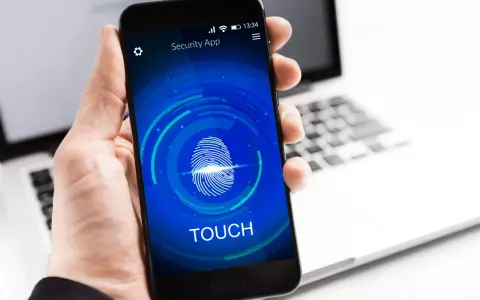 Dłoń trzyma smartfon z ekranem blokady "Security App" i ikoną odcisku palca. Proces autoryzacji jest w toku.