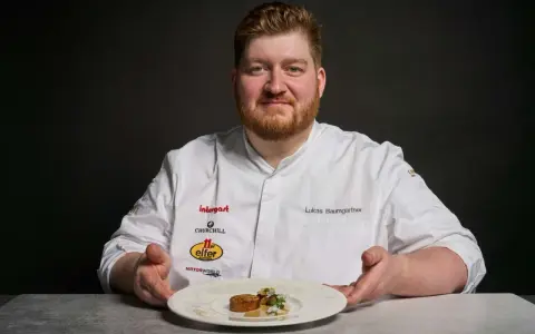 Lukas Baumgartner präsentiert ein Gericht, das an den Heiligen Laurentius erinnert, mit einer kunstvollen Garnitur.