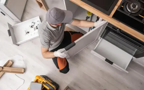 Instalador trabajando en la reforma de cocina, montando cajones y armarios.