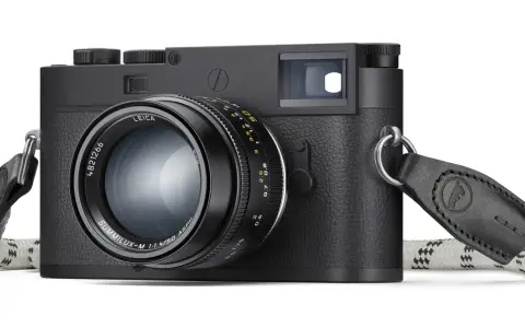 Leica M11 Monochrom, cámara negra con lente Summilux-M 50mm f/1.4 y correa de cuero.
