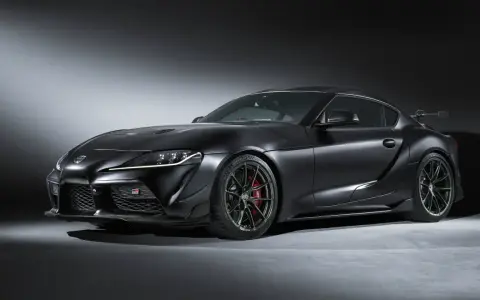 Matowa czerń podkreśla agresywną sylwetkę sportowego coupe Toyota GR Supra. Widoczne czerwone zaciski hamulcowe i aerodynamiczne dodatki.
