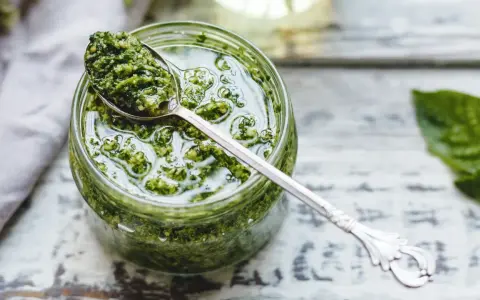 Un cucchiaio di fresco pesto genovese frullatore, pronto per condire la pasta.