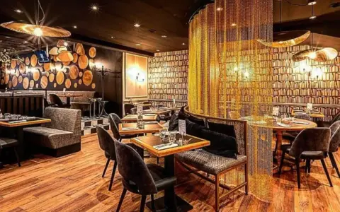 Intérieur chic du restaurant Letz, avec des tables dressées, des banquettes confortables et un rideau de chaînes dorées.