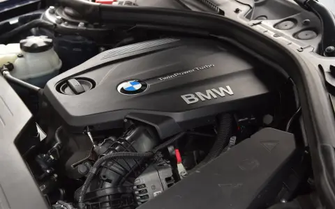 Silnik BMW TwinPower Turbo, prawdopodobnie 2.0 diesel, z widocznym logo BMW i elementami osprzętu.